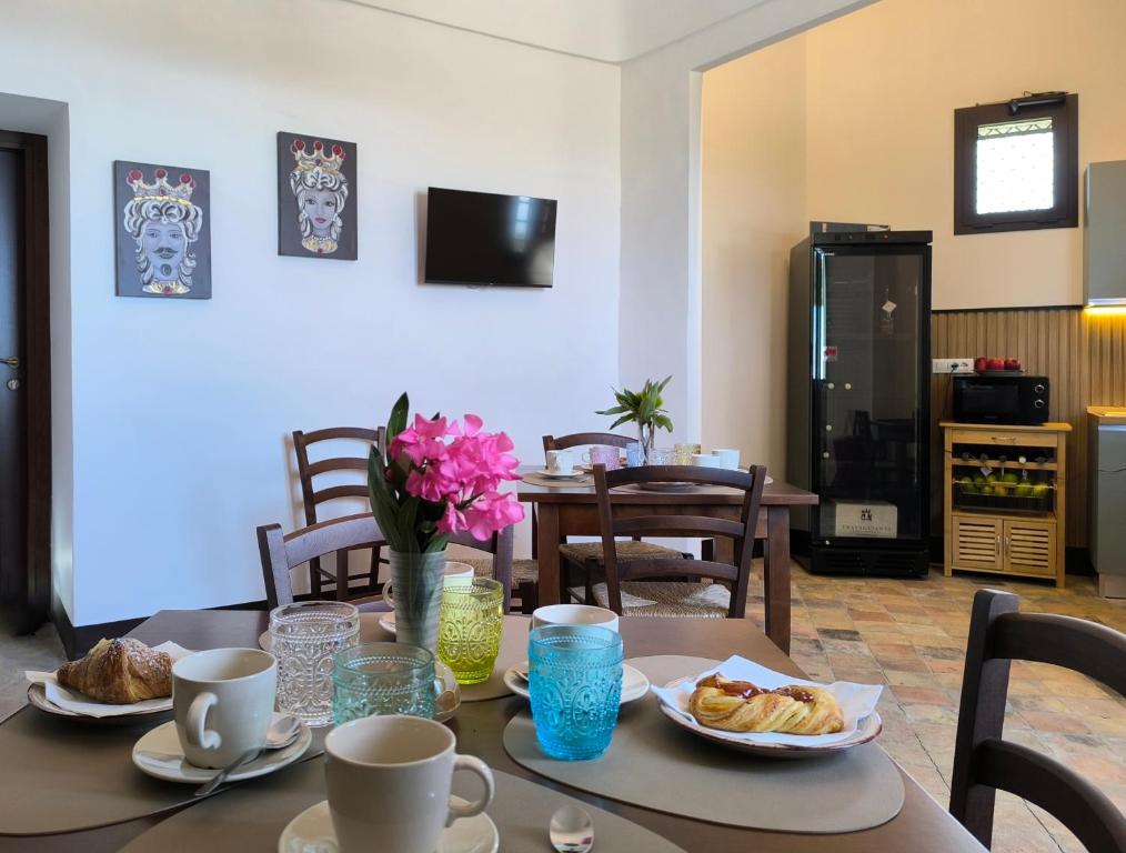 a table with cups and plates of food on it at Agriturismo Travaglianti Alloggio Etna in Ragalna