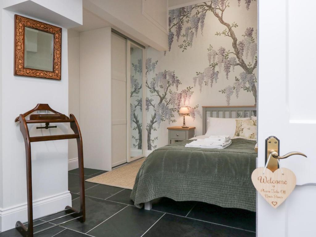 a bedroom with a bed and a mirror on the wall at Pippins in Ambleside