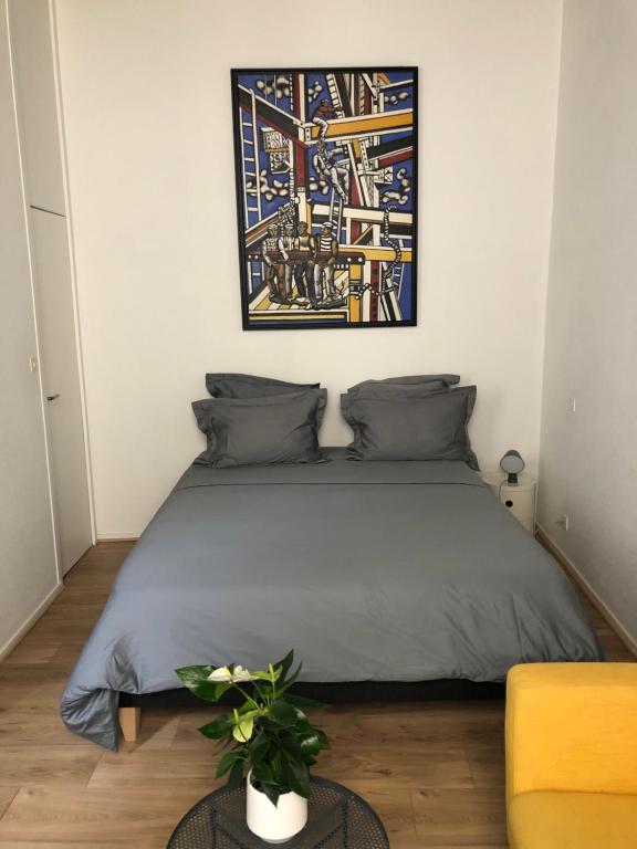 a bedroom with a bed and a picture on the wall at Studio Anna centre historique Bordeaux St Pierre in Bordeaux