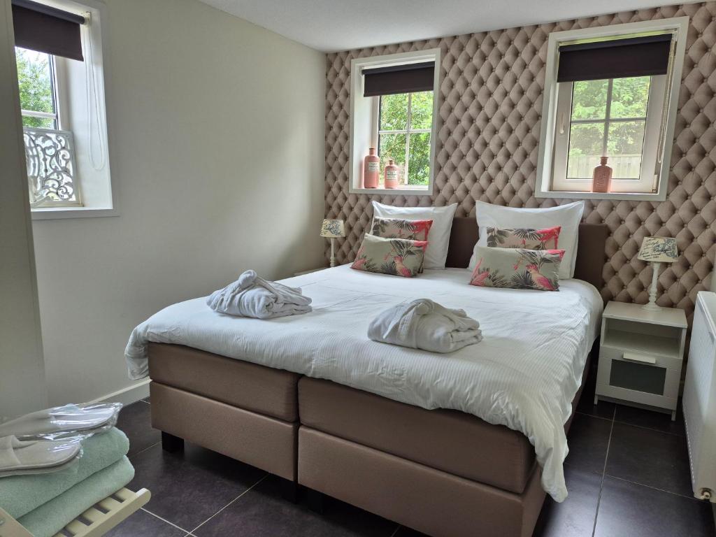 een slaapkamer met een groot bed met twee kussens bij B&B vakantieappartementen Dalerheugte in Dalerveen