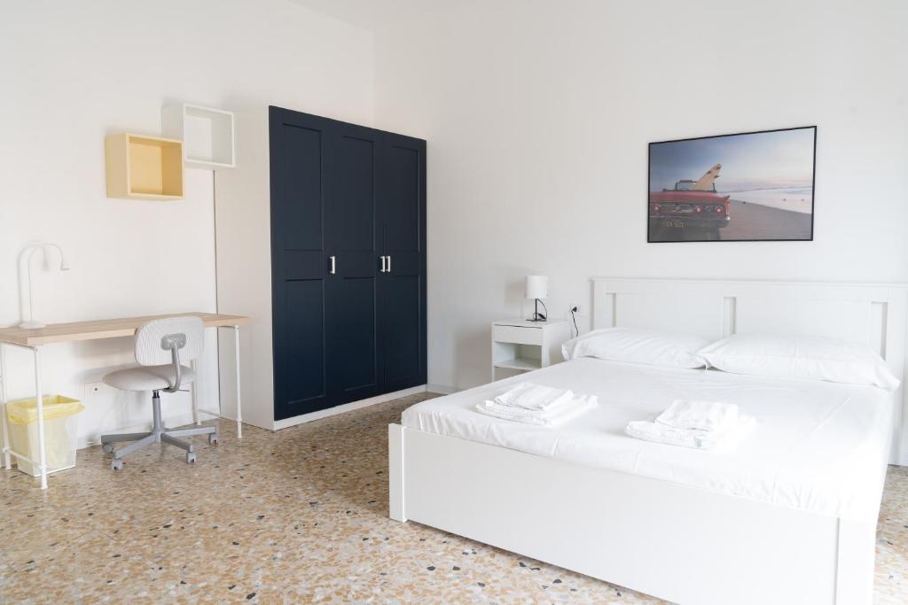 a bedroom with two white beds and a black cabinet at Stadium Residence in Brescia