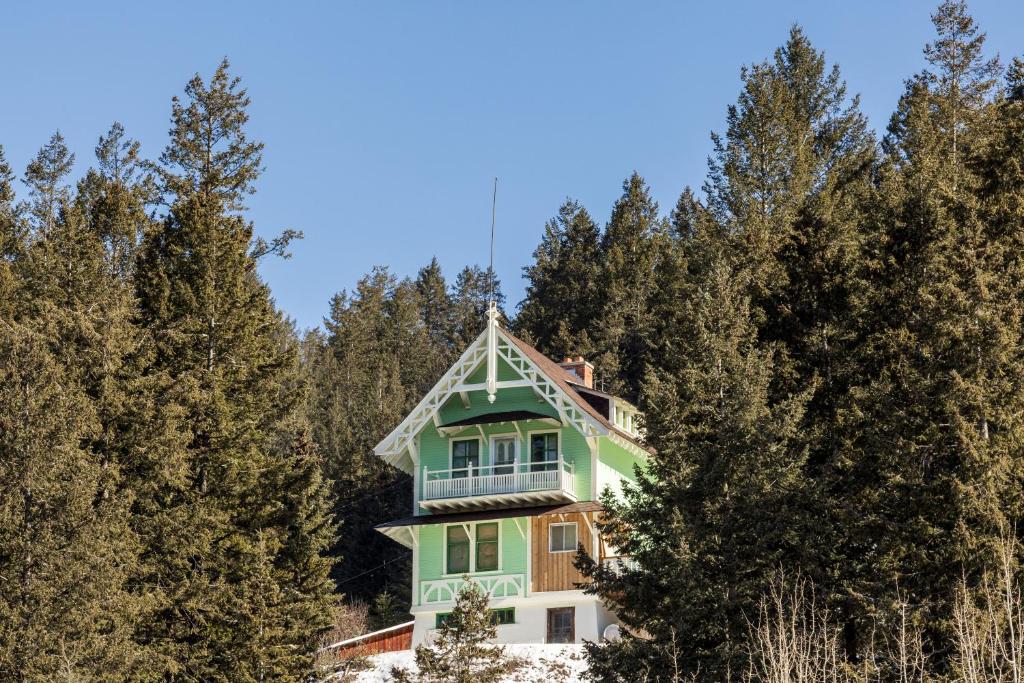 a green house in the middle of trees at Chalet Ernest Feuz - Edelweiss Village in Golden