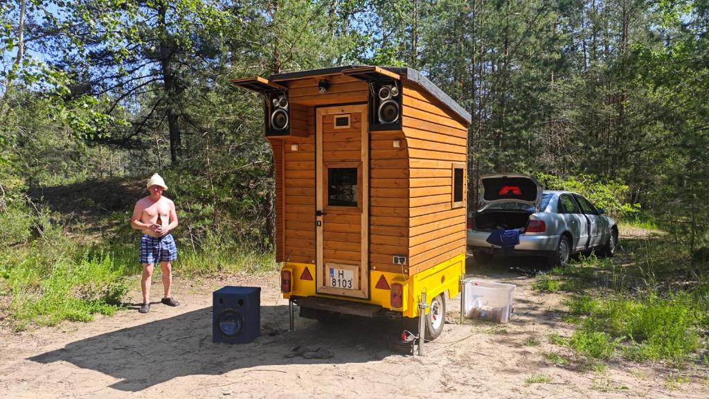 リガにあるDisco Sauna - Portableの小屋の前に立つ男