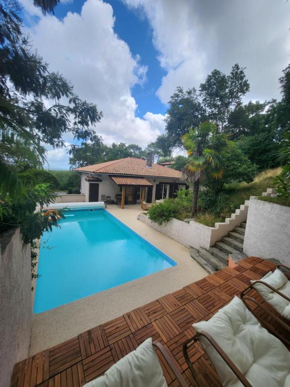 a swimming pool in front of a house at Villa Piscine près Golf Arcachon in La Teste-de-Buch