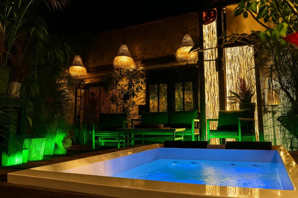 a swimming pool in a room with green lighting at Il Giardino di Chiara in Oristano