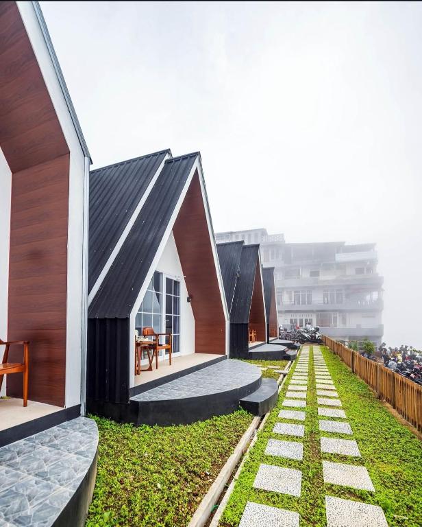 a building with a black roof on top of a yard at Glamping Sarangan in Sarangan