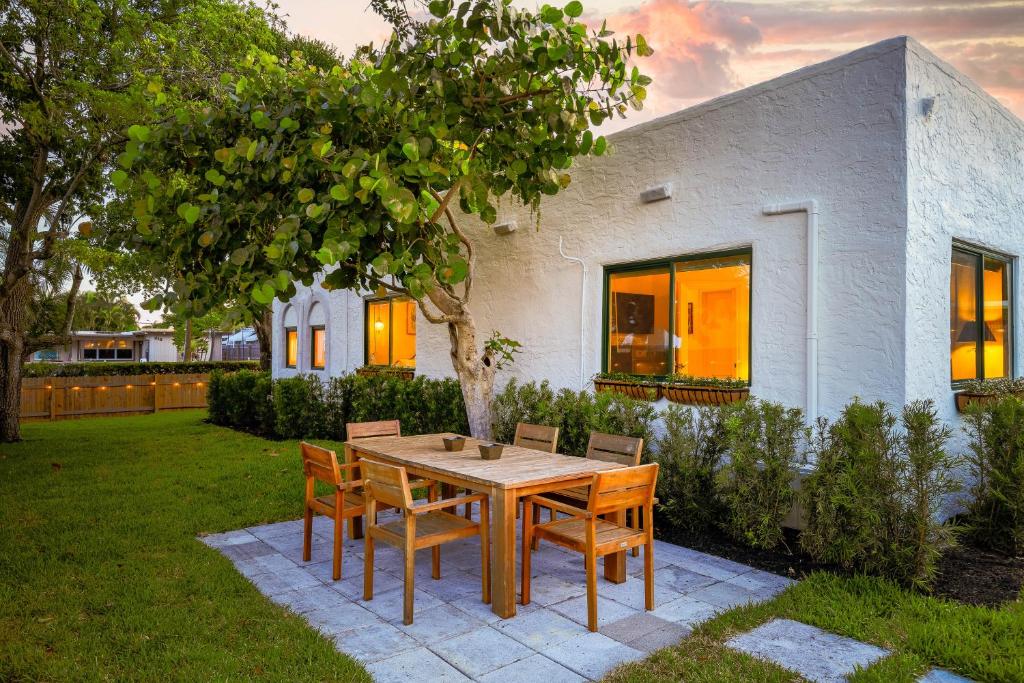 una mesa de madera y sillas en un patio en 3 Mi to Norton Museum of Art Spanish Revival Gem, en West Palm Beach