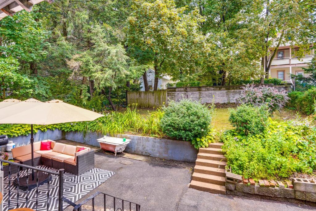 a patio with an umbrella and a table and chairs at Steps to Union College: Home w/ Shared Yard! in Schenectady