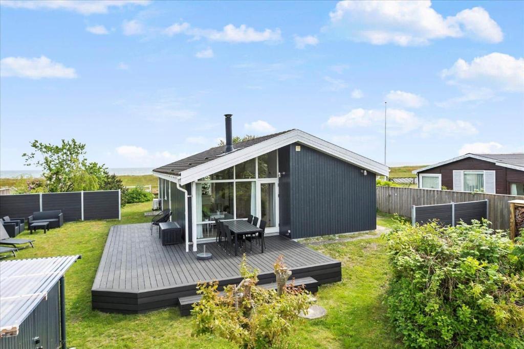 a small house with a deck in a yard at 1060-Stege-Ulvshalevej-213 in Stege
