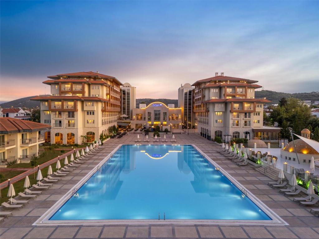 een uitzicht op een groot zwembad voor de gebouwen bij Radisson Blu Resort & Spa Cesme in Çeşme