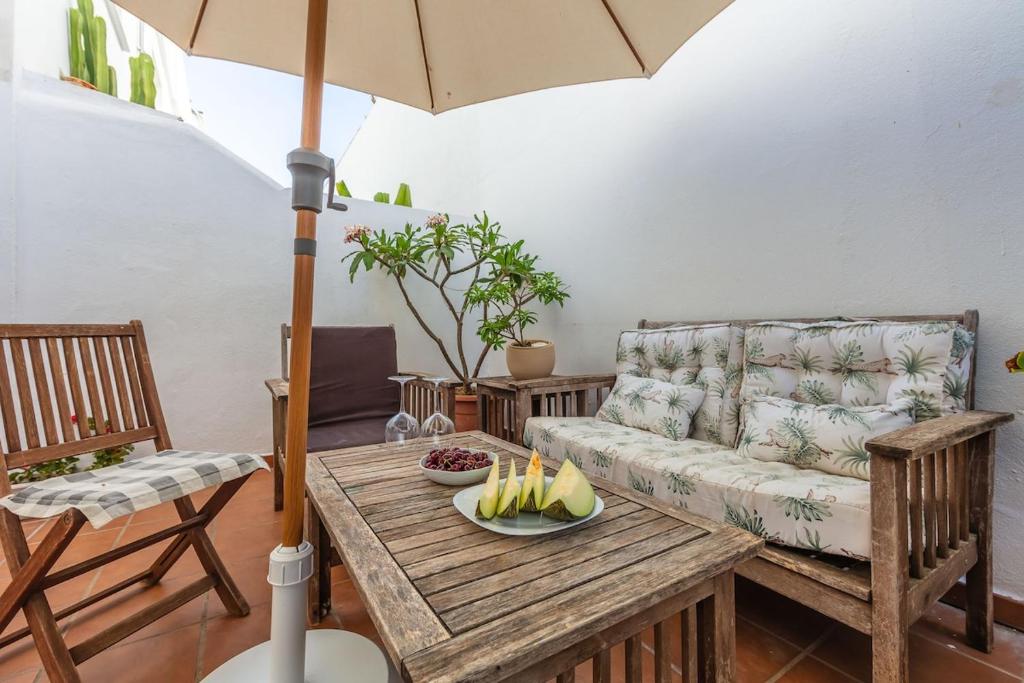 Una sala de estar con un sofá, una mesa y una sombrilla. en Casa Pez 2 minutes from the beach, en Tarifa