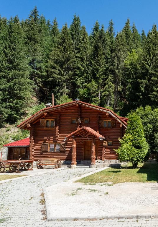 a log cabin in the middle of a forest at Cabana Wiarusti in Moieciu de Sus
