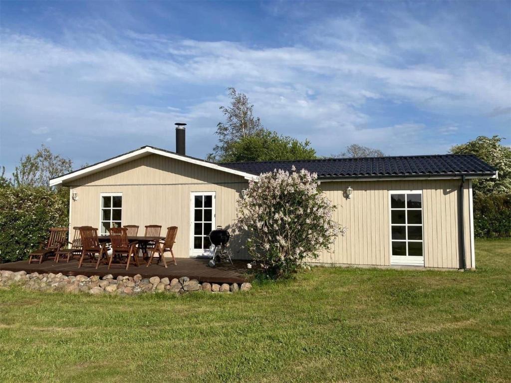 a dog sitting on a deck in front of a house at 7000-Bogo-By-Mosedalen-6 in Bogø By