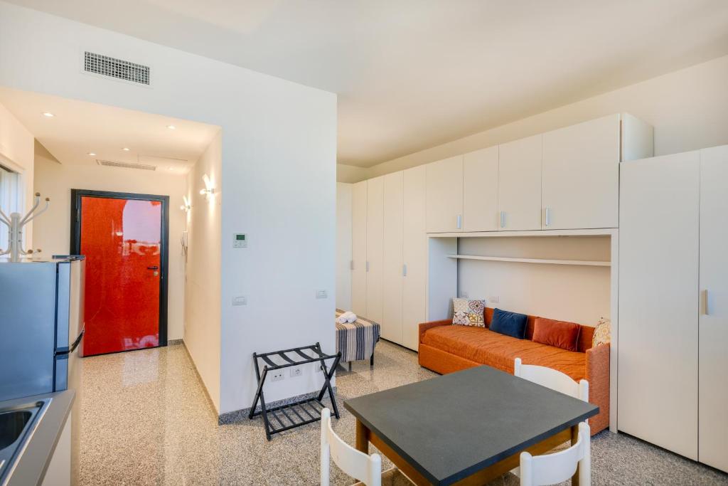 a kitchen and a living room with a couch and a table at Via Moro - Home 47 in Quarto dʼAltino