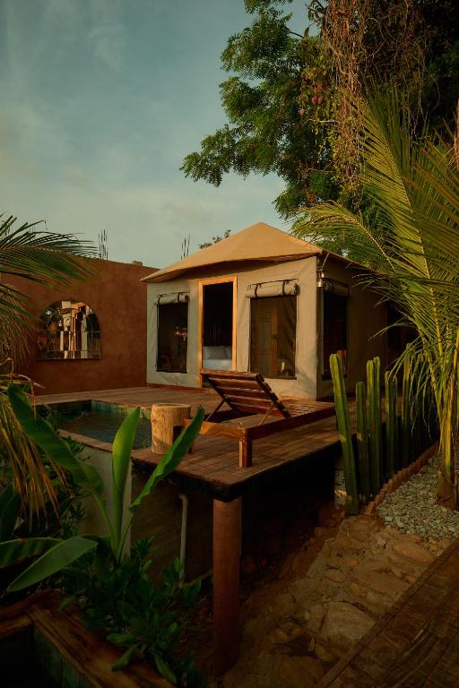 a small home with a deck and a house at Punta Mozambique - Glamping de lujo con AC in Puerto Escondido