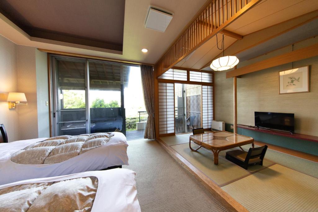 une chambre avec un grand lit et une table dans l'établissement Ryokan Kiritani Hakoneso, à Hakone
