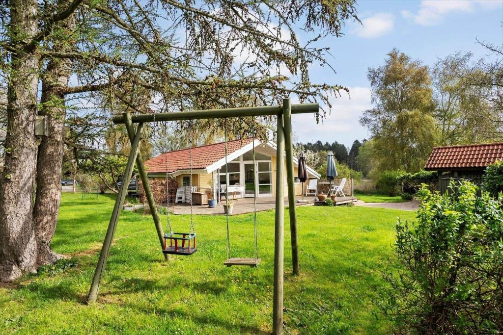 een schommel in een tuin naast een boom bij 3064-Stege-Maegleren-34 in Stege