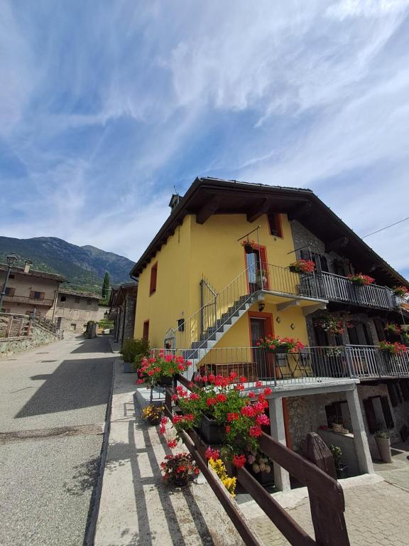 a yellow building with flowers in front of it at La meison de Ciamy in Aosta