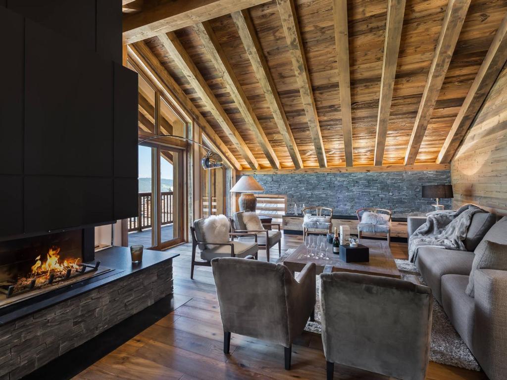 un salon avec un canapé et une cheminée dans l'établissement Duplex lumineux 5 chambres en-suite, sauna, proche pistes et commerces, Méribel Village - FR-1-566-10, à Les Allues