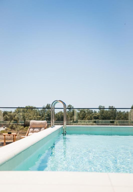 a swimming pool with a chair sitting next to it at Cervino in Ulcinj