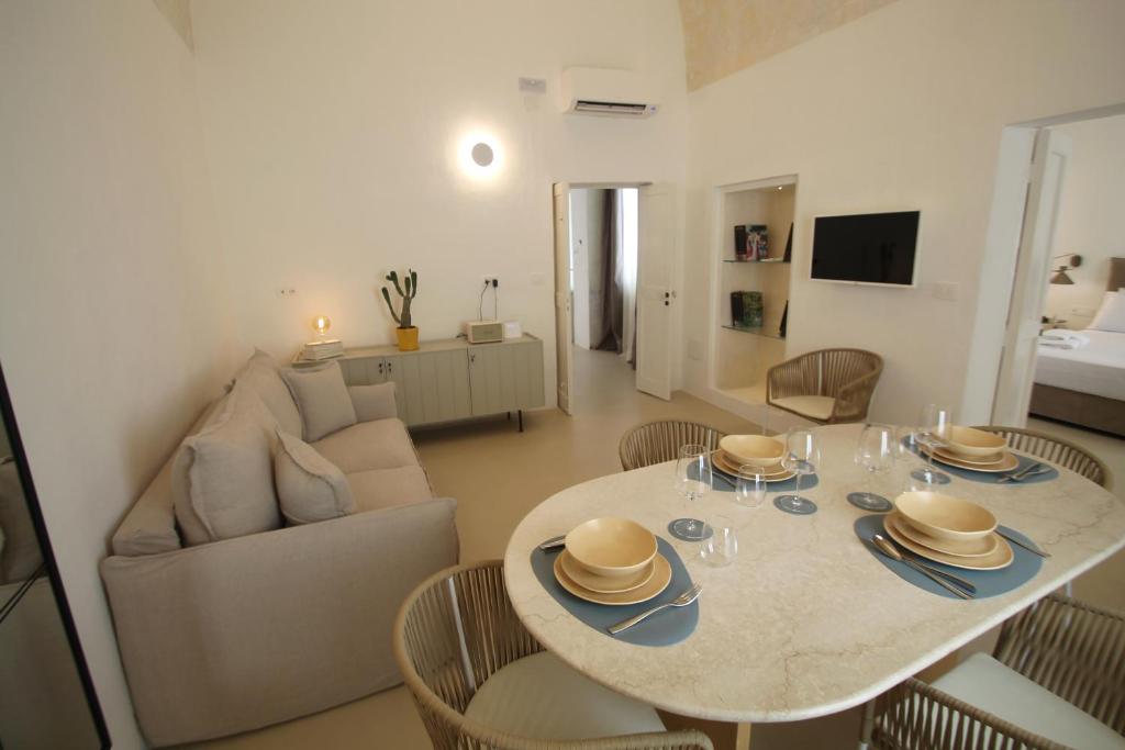 a living room with a table with chairs and a couch at Casa Di Benedetta in Gallipoli