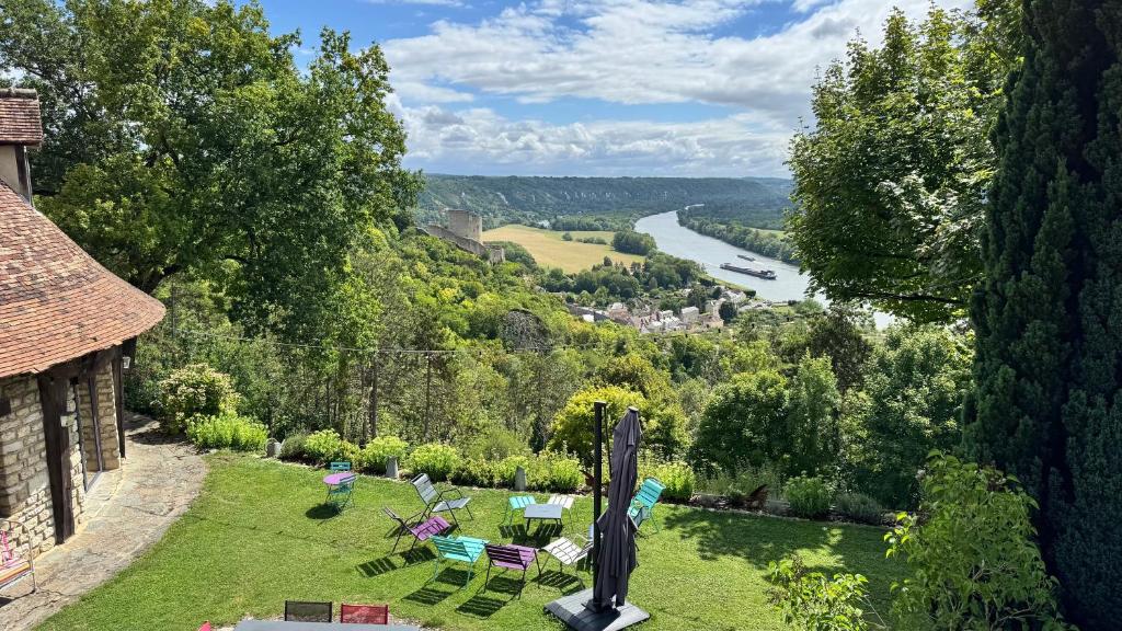 Un jardín con sillas y vista a un río. en Le Paradis de Lucile, vue de rêve, Giverny 10 minutes, en La Roche-Guyon