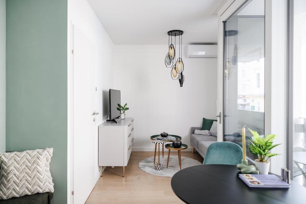 una sala de estar con una mesa y un sofá en Stylish City Suite, Balcony, Augarten & Center, en Viena