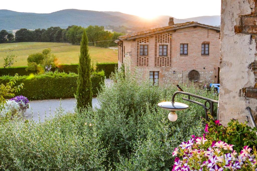 widok na dom w ogrodzie z kwiatami w obiekcie Casa Di Campagna In Toscana w mieście Sovicille