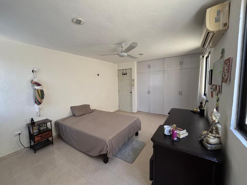 a bedroom with a bed and a table in it at CASA COLIBRÍ - Solo Mujeres! & lgbt friendly in Mérida