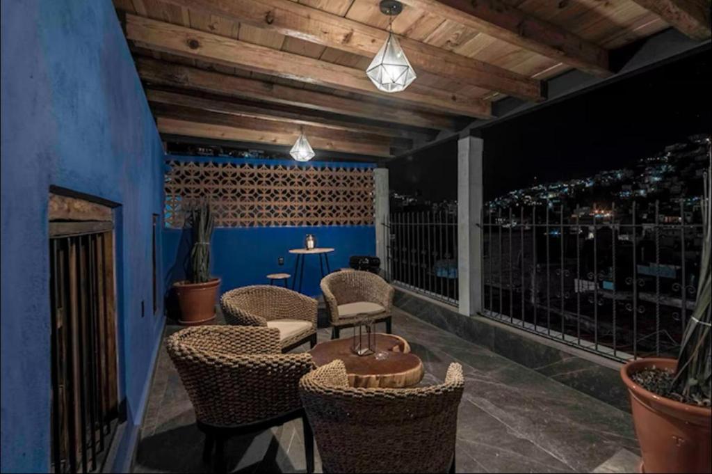 a patio with chairs and a table with a view of a bar at Casa Paulina in Guanajuato