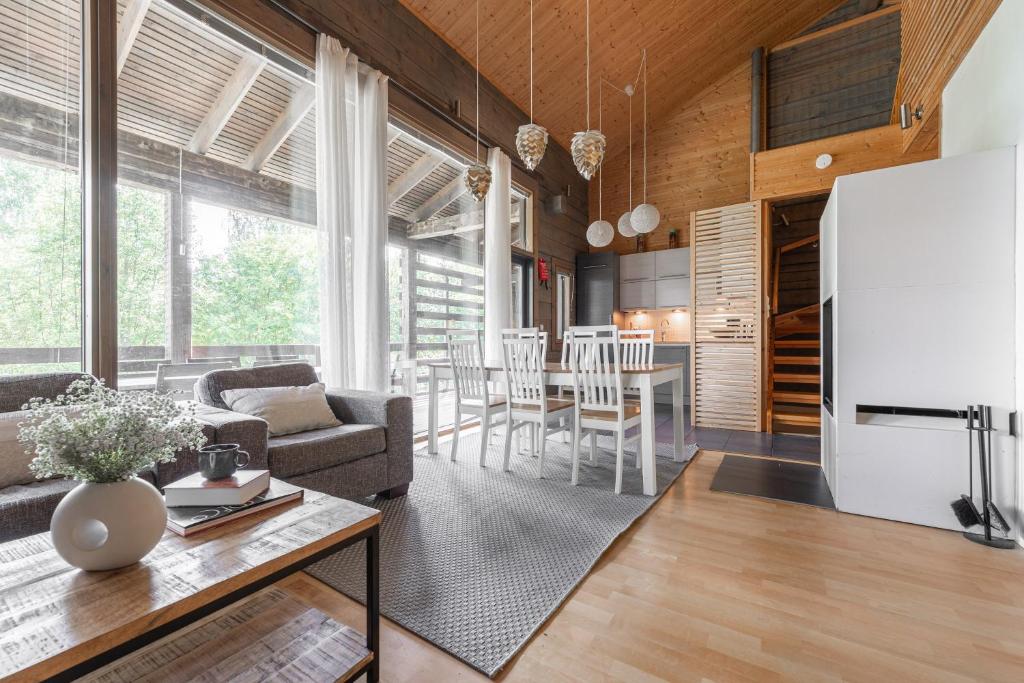 a kitchen and living room with a large white refrigerator at Villa Kultaranta A - Scenic Lakeside Cabin in Tahkovuori with Hot Tub and Sauna in Tahkovuori