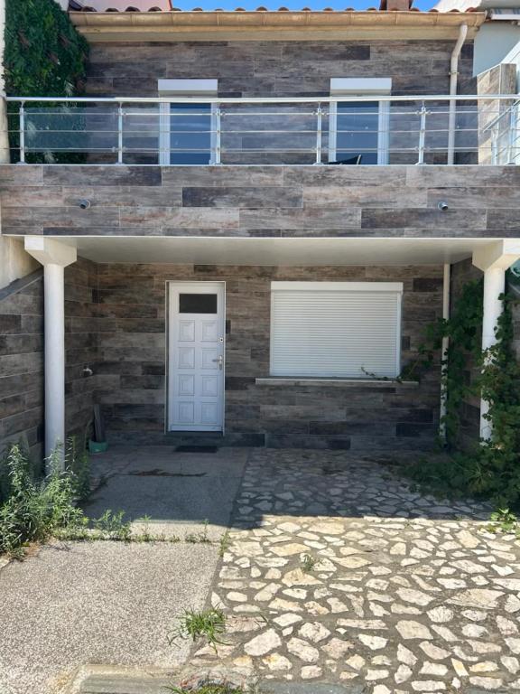 uma casa com duas portas de garagem e uma varanda em Maison face a la mer em Sainte-Marie-la-Mer