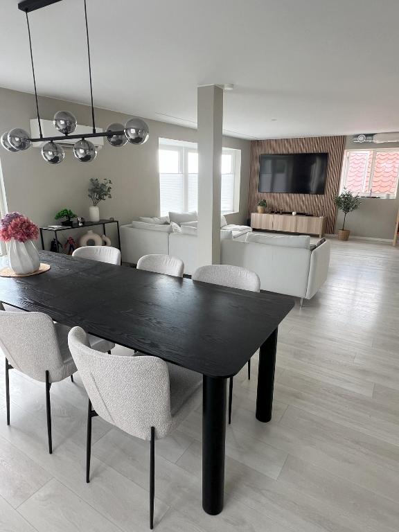 a dining table and chairs in a living room at Large house with 3 bedrooms and a private garden in Stavanger