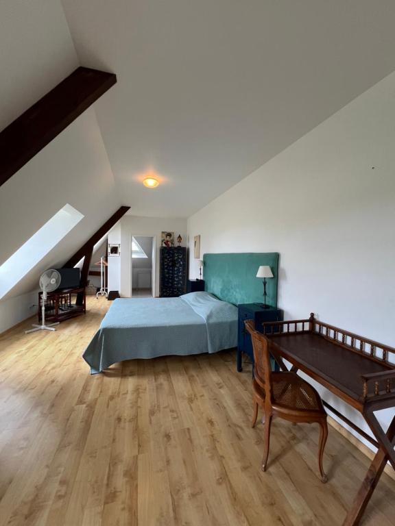 Un dormitorio con una cama y suelo de madera. en Beth Soureilh Adults Only, en Coarraze