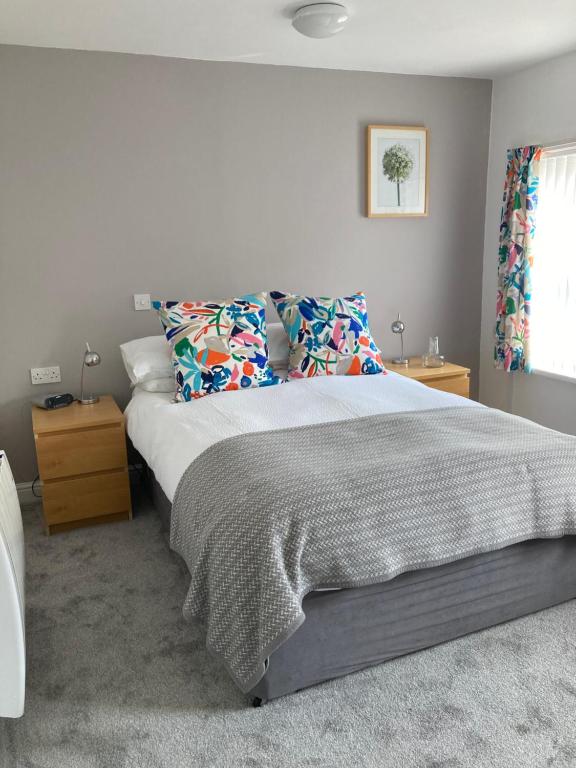 een slaapkamer met een groot bed met kussens bij Ludford View, riverside cottage in Ludlow with private parking in Ludlow