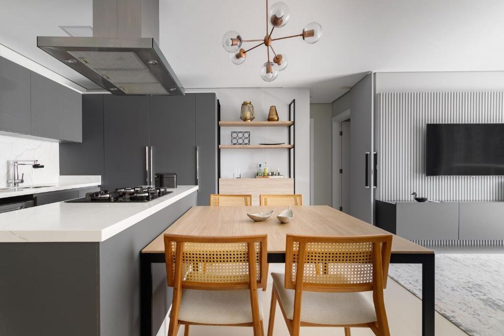 a kitchen with a wooden table and two chairs at Apto 2 Quartos com Sacada Ed.Jardim Milano in Florianópolis