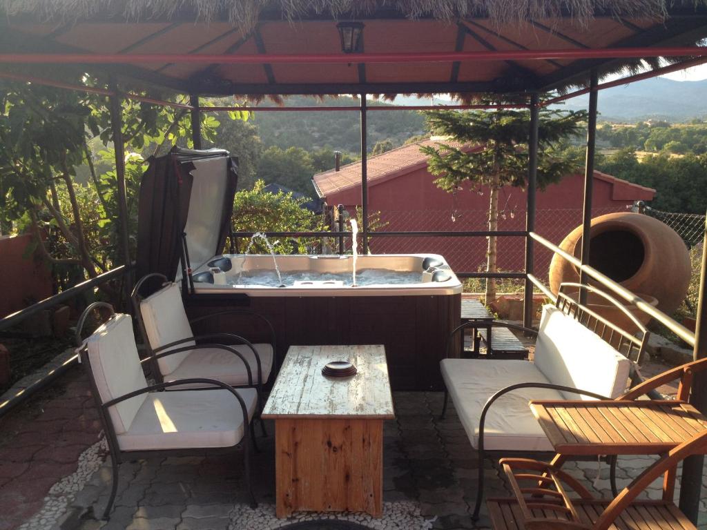 a patio with a tub and chairs and a table at Casa Rural El Fresno in Burgohondo