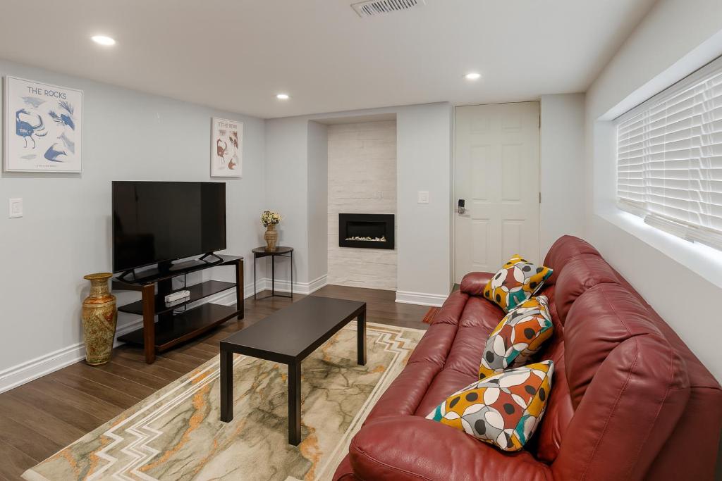 a living room with a leather couch and a table at Cozy 3BR Caledon Basement Suite with Private Access, Backyard Basketball Court, Full Kitchen, WiFi, Laundry, 5 Mins to Brampton, Family Friendly, Near Trails & Parks! in Caledon