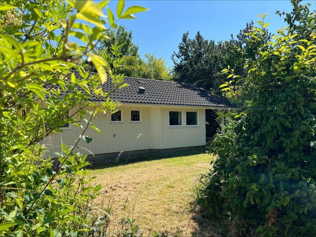 a white house with a yard and trees at 90714-Bogo-By-Hojdedraget-56 in Bogø By