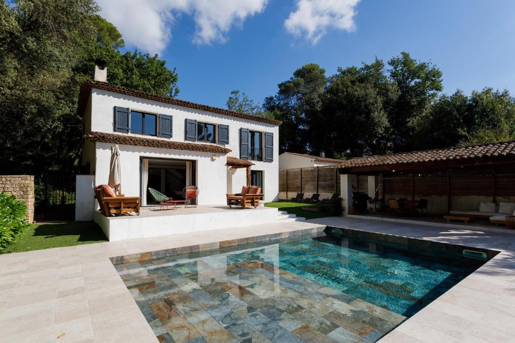 une maison avec une piscine devant une maison dans l'établissement Villa zen rénovée 4 ch, terrain de basket privé, à Mougins