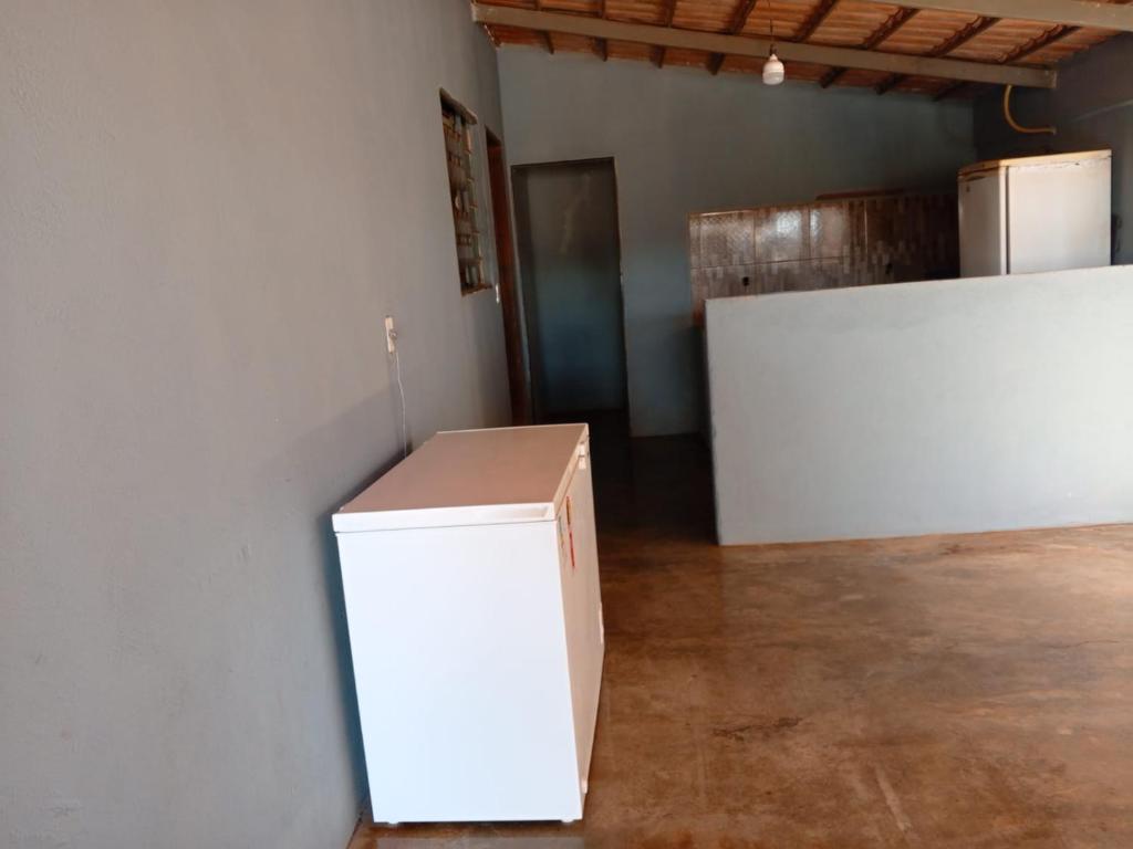 une boîte blanche posée dans une pièce avec un réfrigérateur dans l'établissement Casa de Temporada WK, à Campo Alegre
