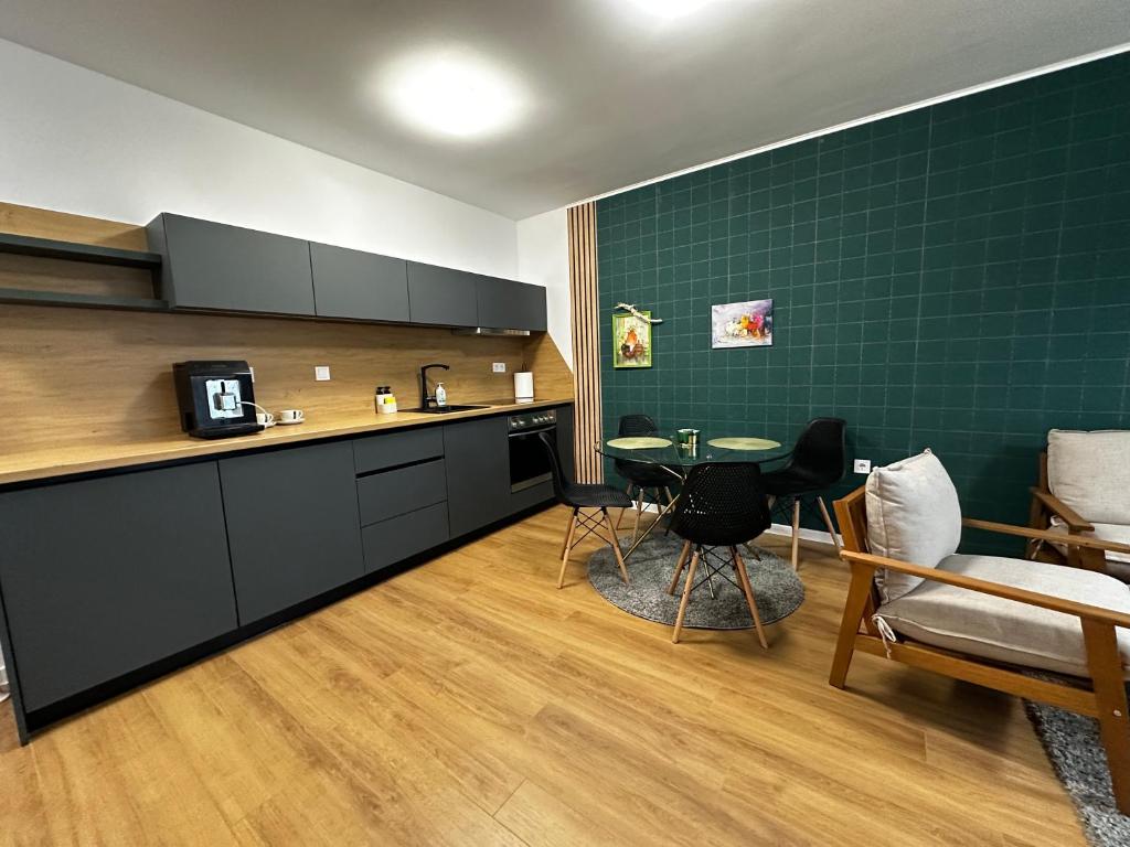 a kitchen with a table and a green wall at Delux 3 - Plovdiv Модерен апартамент,2 спални,център in Plovdiv