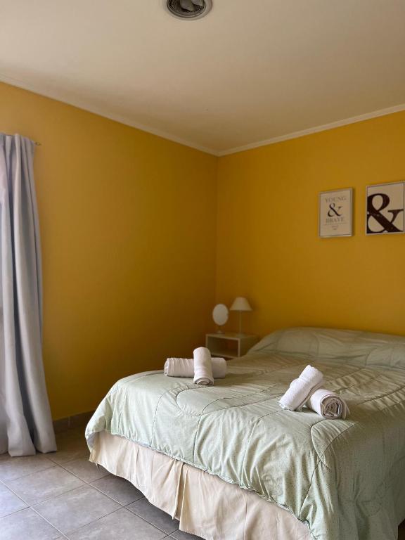 a bedroom with a bed with yellow walls at Las Lilas in Roque Pérez