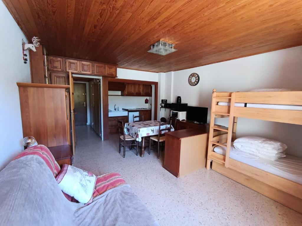 - une chambre avec des lits superposés, un bureau et une table dans l'établissement Résidence Alpet Ii - Studio spacieux,agréable, superbe vue pistes plein sud, parking. MAE-8104, à Montgenèvre