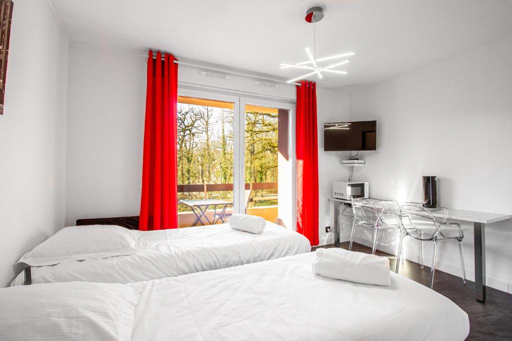 Zimmer mit 3 Betten und einem Fenster mit roten Vorhängen in der Unterkunft Sweet-Thermal Amnéville loisir, parking gratuit in Amnéville