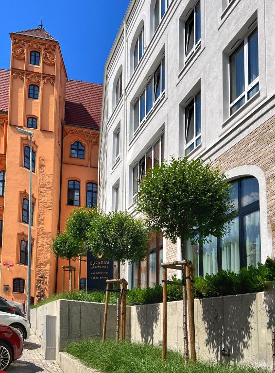 budynek z wieżą zegarową przed nim w obiekcie Kurkowa Apartments w Szczecinie