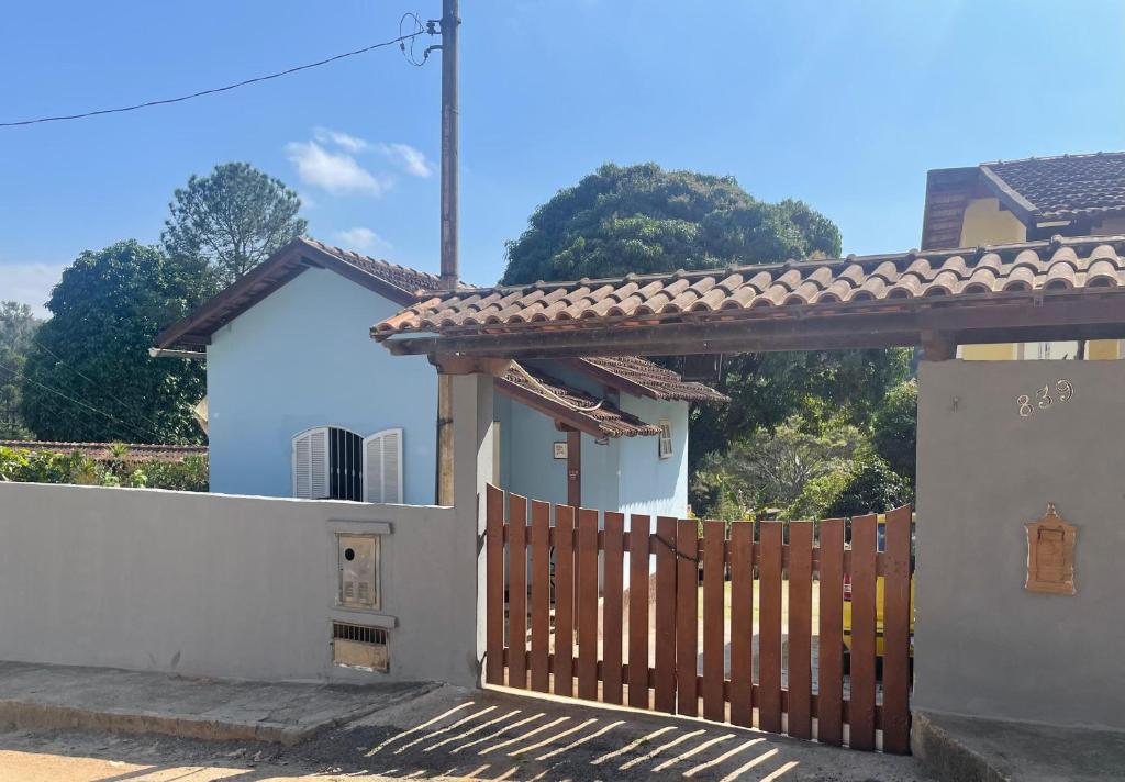 a house with a wooden gate and a fence at Cantinho da Paz in Miguel Pereira