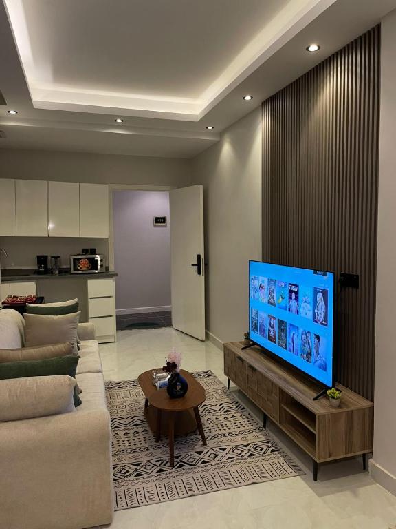 a living room with a couch and a flat screen tv at شقة راقية وفاخرة in Riyadh