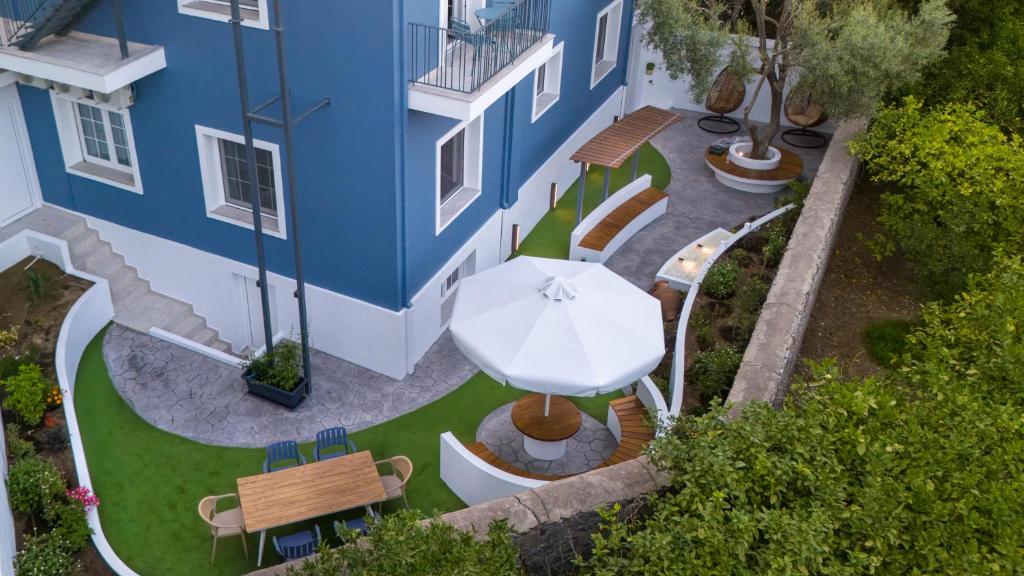an overhead view of a patio with a white umbrella and benches at Secret Garden Studios in Mytilene