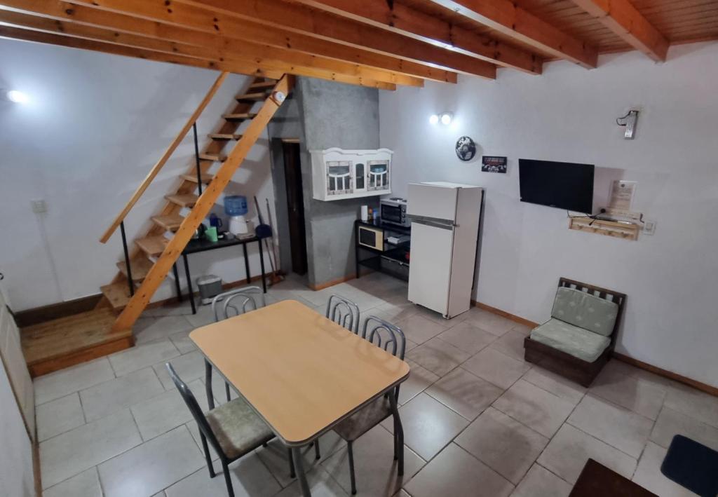 a kitchen and dining room with a table and a refrigerator at MotoHouse-Tl in Trenque Lauquen